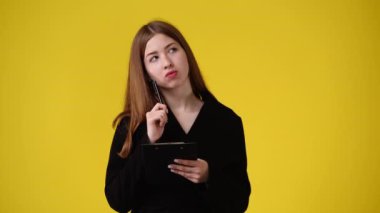 4k video of one girl taking notes over yellow background. Concept of emotions.