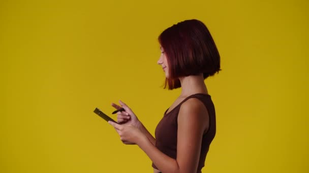 黄色い背景に思慮深い表情の女の子の4K動画 アイデアを持つ少女の概念 — ストック動画