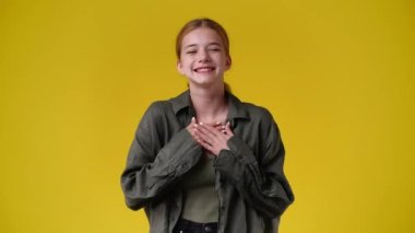 4k video of smiling girl over yellow background. Concept of emotions.