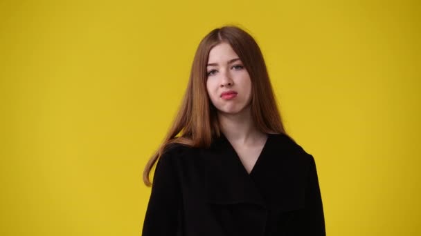 黄色の背景の上に悪い感じの1人の女の子の4Kビデオ 感情の概念 — ストック動画