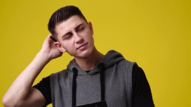 4k video of a man thinking about something over yellow background. Concept of emotions.