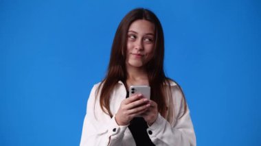 .4k video of one girl sending messages on blue background. Concept of emotions.