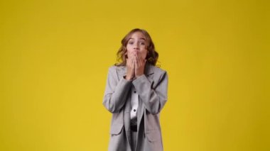4k video of one girl showing thumbs up over yellow background. Concept of emotions.