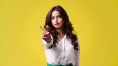 Sarı arka plandaki bir şeye negatif tepki veren bir kızın 4K videosu. Duyguların kavramı.