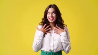 4k video of one girl who is embarrassed to receive compliments over yellow background. Concept of emotions.