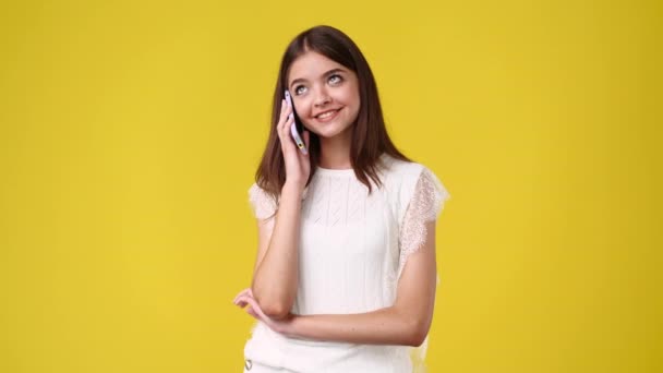 Vídeo Uma Garota Falando Telefone Com Alguém Sobre Fundo Amarelo — Vídeo de Stock
