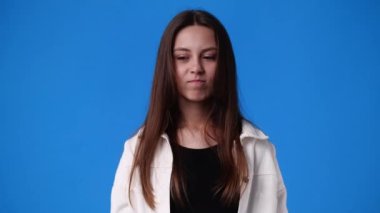 4k video of one girl closes the nose against the smell over blue background. Concept of emotions.