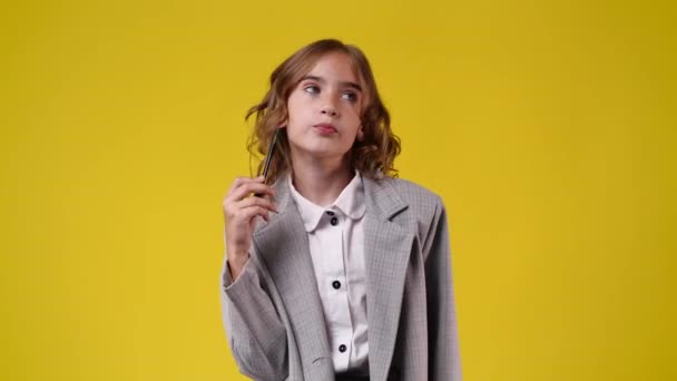 Elinde Kalemle Bir Şeyler Planlayan Bir Kızın Videosu Sarı Arka — Stok video
