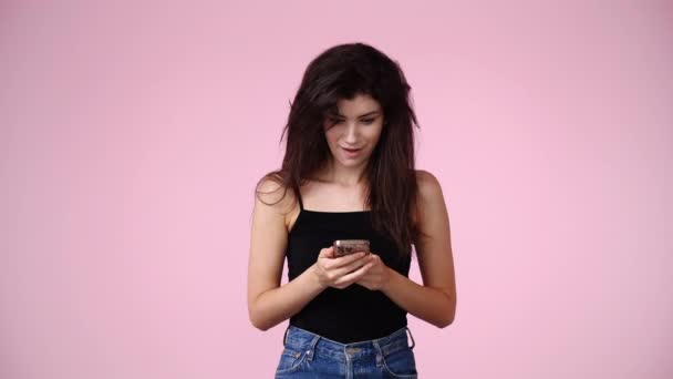 素敵なメッセージを受け取りピンクの背景の上に幸せ1人の女の子の4Kスローモーションビデオ 感情の概念 — ストック動画