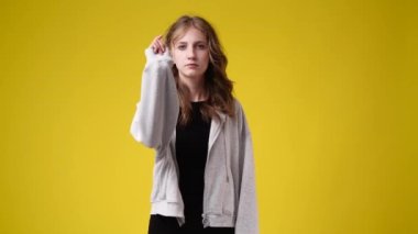 4k slow motion video of one girl stops and prohibits over yellow background. Concept of emotions.