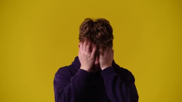 黄色の背景の上に頭痛のある男の4Kビデオ 感情の概念 — ストック動画
