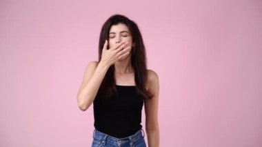 Pembe arka planda poz veren bir kızın 4K videosu. Duyguların kavramı.