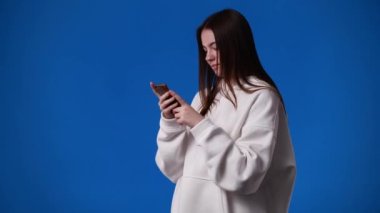 4k video of one girl sending messages on blue background. Concept of emotions.