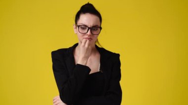 Sarı arka planda poz veren bir kızın 4K videosu. Duyguların kavramı.