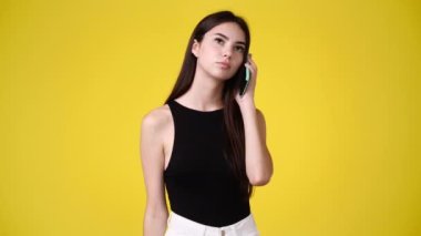 Sarı arka planda poz veren bir kızın 4K videosu. Duyguların kavramı.