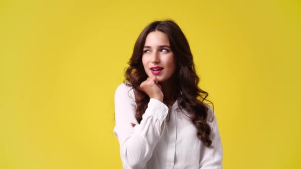 Zeitlupe Video Von Mädchen Mit Listigen Gesichtsausdruck Auf Gelbem Hintergrund — Stockvideo