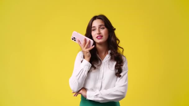 4K视频 一个女孩用黄色背景的扩音器和别人通电话 情绪的概念 — 图库视频影像