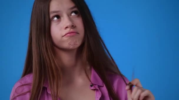 Videó Egy Lányról Aki Játszik Hajával Valami Kék Háttérre Gondol — Stock videók