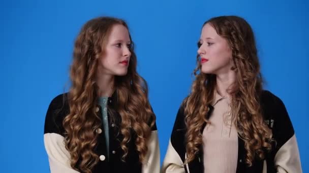 Birbirlerine Bakıp Mavi Arka Planda Gülen Ikiz Kızların Videosu Duyguların — Stok video