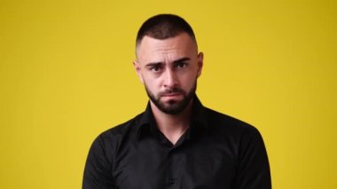 Sarı arka plana çok kızgın bir adamın 4K videosu. Duyguların kavramı.