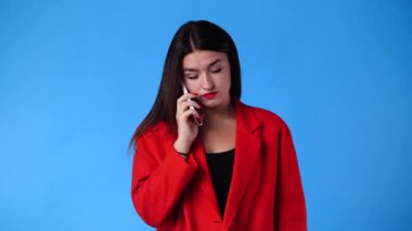 Bir kadının mavi arkaplan üzerinden birini aramaya çalıştığı 4K video. Duyguların kavramı.
