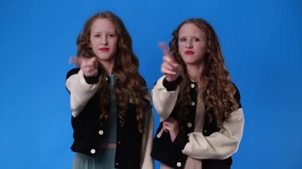 否定的な表情をした双子の女の子の4K動画は停止し 青の背景の上に禁止されています 感情の概念 — ストック動画