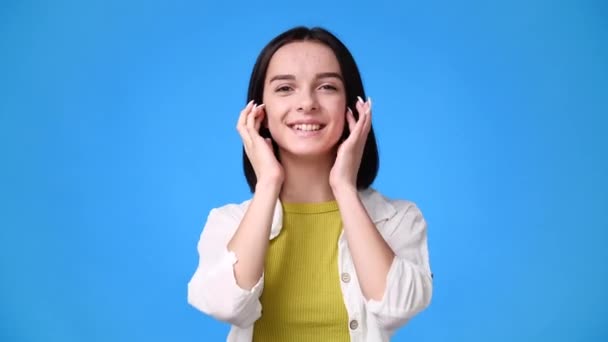 1人の女の子の4Kビデオは彼女の髪を修正し 青の背景に甘い笑顔 感情の概念 — ストック動画