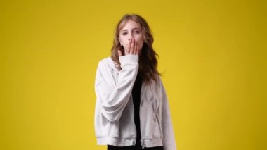 4k video of cute girl smiling over yellow background. Concept of emotions.