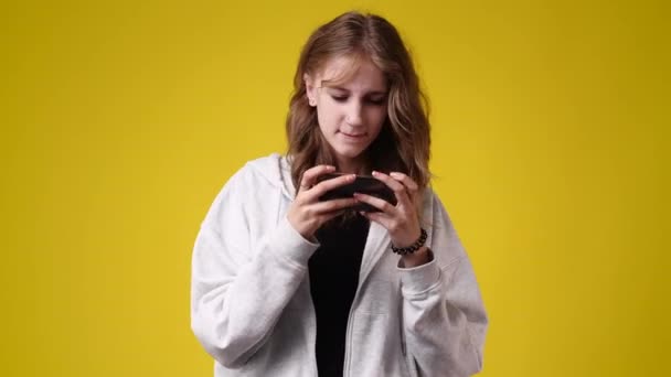 黄色の背景にメッセージを送る少女の4K動画 感情の概念 — ストック動画