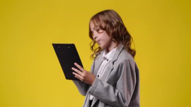 4k video of one girl taking notes over yellow background. Concept of emotions.
