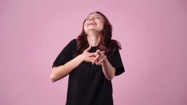 4k video of one girl posing for a video over pink background. Concept of emotions.