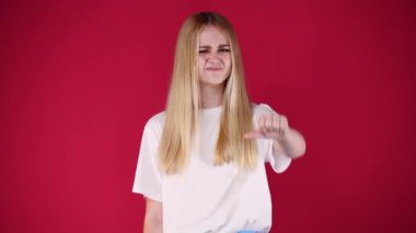 Kırmızı arka planda başparmağını gösteren 4K video. Olumsuz duygu kavramı.