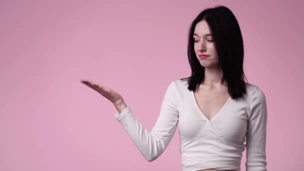 Filmik Jedną Dziewczyną Wskazującą Lewo Pokazującą Kciuk Różowym Tle Pojęcie — Wideo stockowe