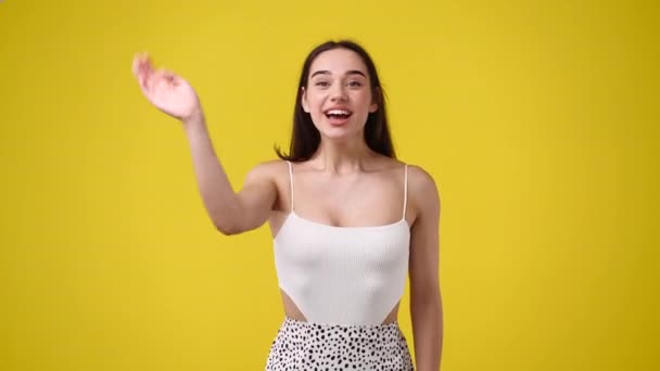 Wideo Cute Girl Macha Cześć Żółtym Tle Pojęcie Emocji — Wideo stockowe