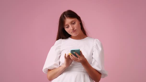 Vídeo Cute Girl Using Phone Pink Background Conceito Emoções — Vídeo de Stock