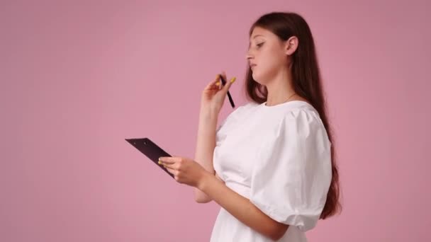 Video One Girl Taking Notes Pink Background Concept Emotions — Stockvideo