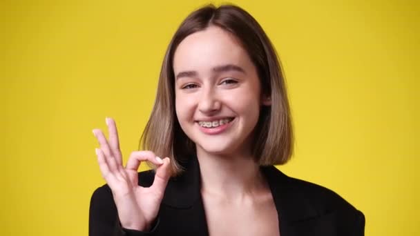Wideo Cute Girl Pokazuje Znak Żółtym Tle Pojęcie Emocji — Wideo stockowe