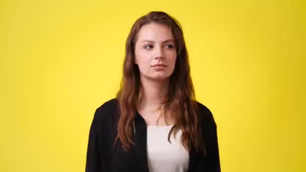 黄色の背景に無音記号を示す1人の少女の4K動画 感情の概念 — ストック動画