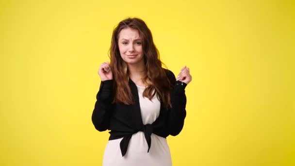 黄色の背景で踊っている1人の少女の4Kビデオ 感情の概念 — ストック動画