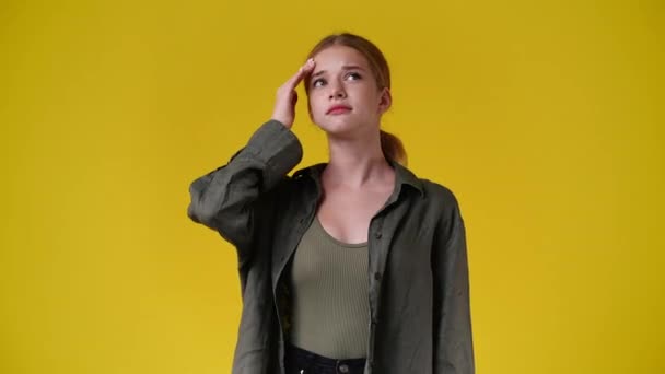 Βίντεο Ένα Κορίτσι Σκέφτεται Κάτι Πάνω Από Κίτρινο Φόντο Έννοια — Αρχείο Βίντεο