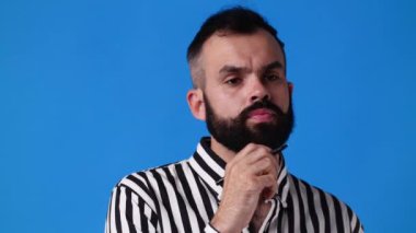 Mavi arka planda gülümseyen adamın 4K videosu. Duyguların kavramı.