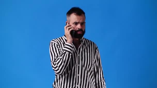 1人の男が携帯電話の青黄色の背景を使って4K動画 感情の概念 — ストック動画
