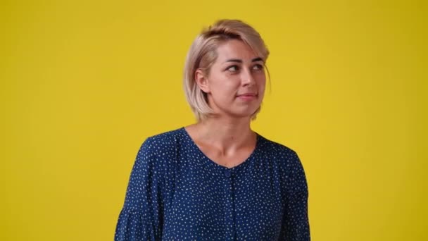 黄色の背景の上にサイレントサインを示す女性の4Kビデオ 感情の概念 — ストック動画
