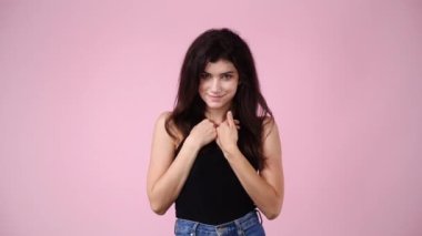 Pembe arka planda dur işareti gösteren bir kızın 4K videosu. Duyguların kavramı.