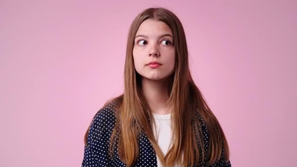 1人の女の子の4K動画が周りを見回し ピンクの背景に無音サインを表示します 感情の概念 — ストック動画