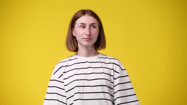 4K视频一个女孩的姿势和梦想的东西在黄色背景 情绪的概念 — 图库视频影像