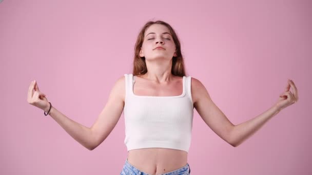 ピンクの背景の上にヨガポーズで瞑想する1人の女の子の4Kビデオ 感情の概念 — ストック動画