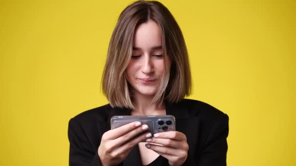 Video Jedné Dívky Přehrává Telefonu Přes Žluté Pozadí Pojetí Emocí — Stock video