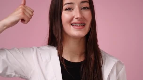 Slow Motion Video One Girl Showing Thumbs Smiling Pink Background — Vídeos de Stock