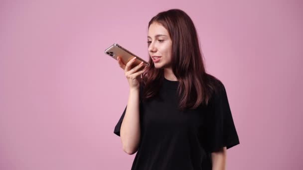 Відео Однієї Дівчини Яка Розповідає Історію Комусь Телефону Рожевому Тлі — стокове відео